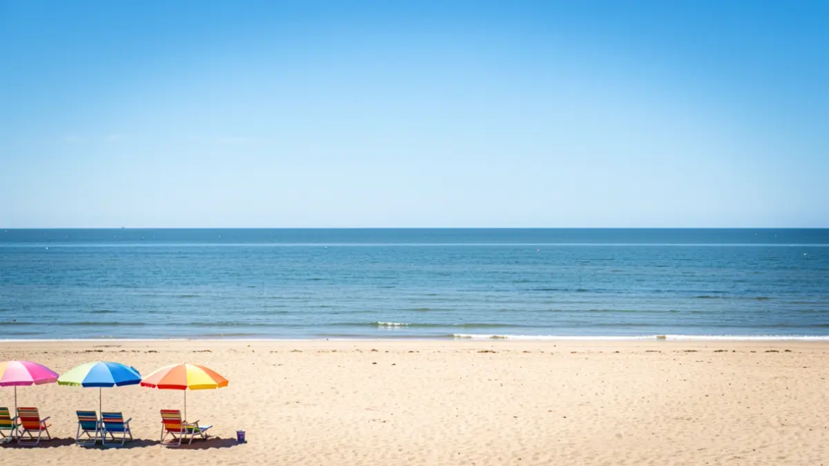 Generic image of a sunny beach with chairs and umbrellas in Knokke-Heist, with the sea and sky in the background.