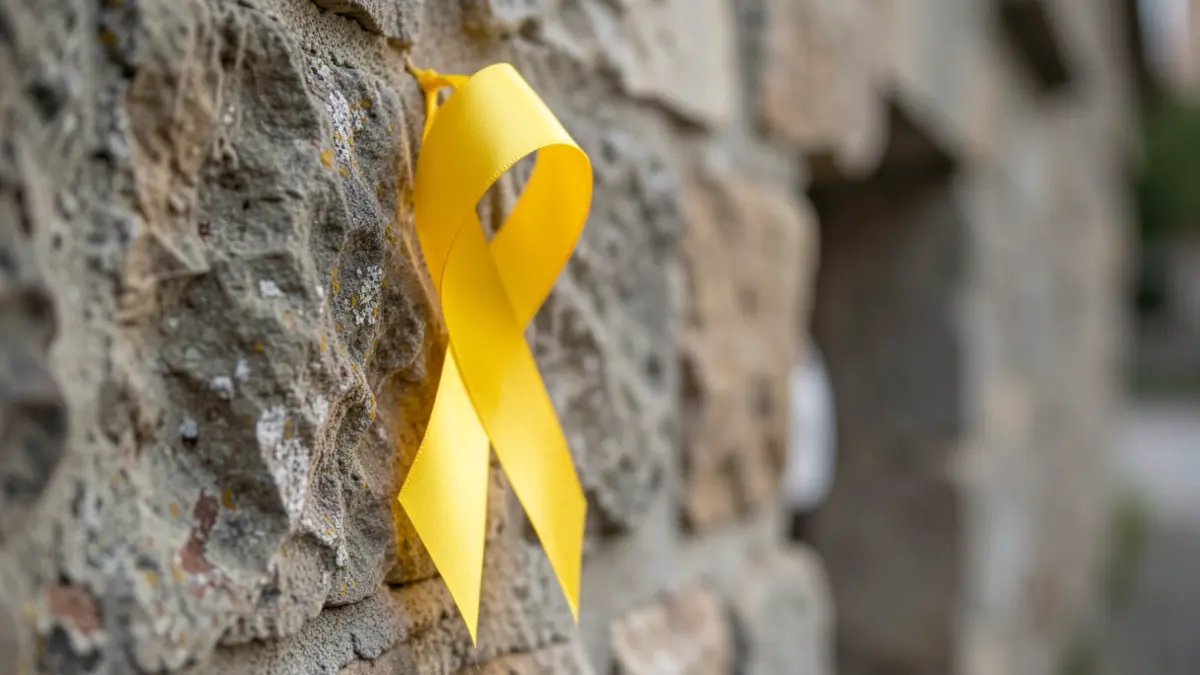 A yellow ribbon tied to a stone wall, symbolizing hope.